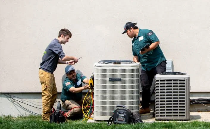 HVAC team working with multiple outdoor air conditioning units