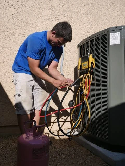 HVAC technician checking an outdoor air conditioning unit
